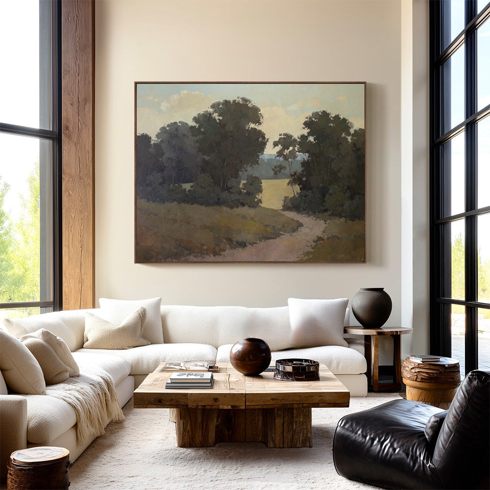 Original 60x77 landscape painting "Quiet Process" by Ashley Ozmint.  Trees in field with a dirt path and a cloudy sky. Painting in modern living room.
